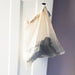 cotton mesh drawstring bag with socks inside hung on a door handle