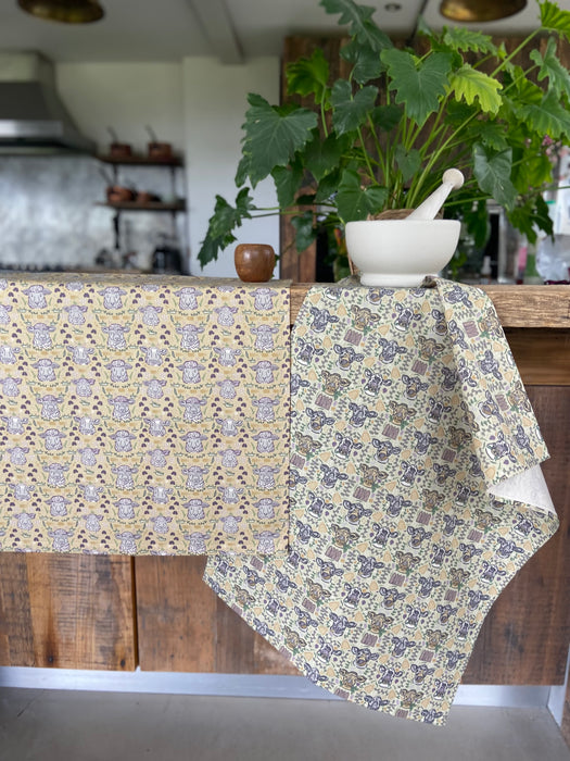 Poker Faced Tea Towel Set in kitchen, draped over wooden counter top.