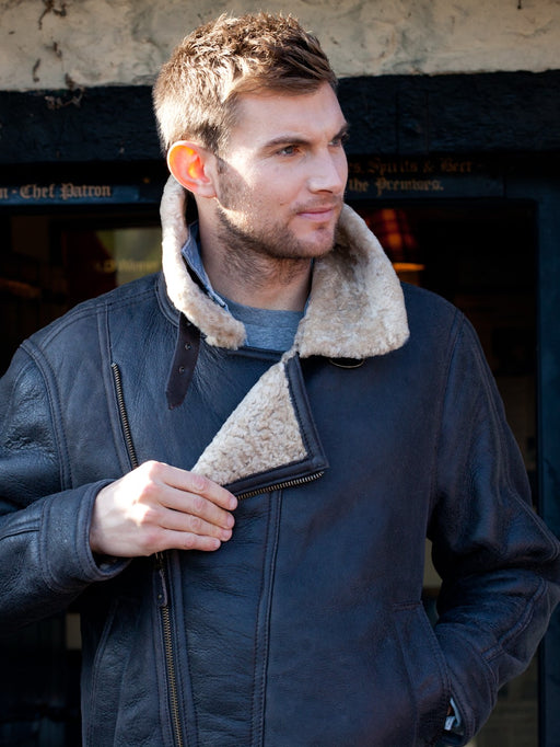 Men's Sheepskin and Leather Blenheim Chocolate Aviator Jacket. Male model wears jacket, undoing the front zip.