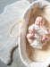 Smiling baby laid on sheepskin stroller liner in a moses basket next to a Grey Sheepskin Nursing rug on the floor in a nursery playroom