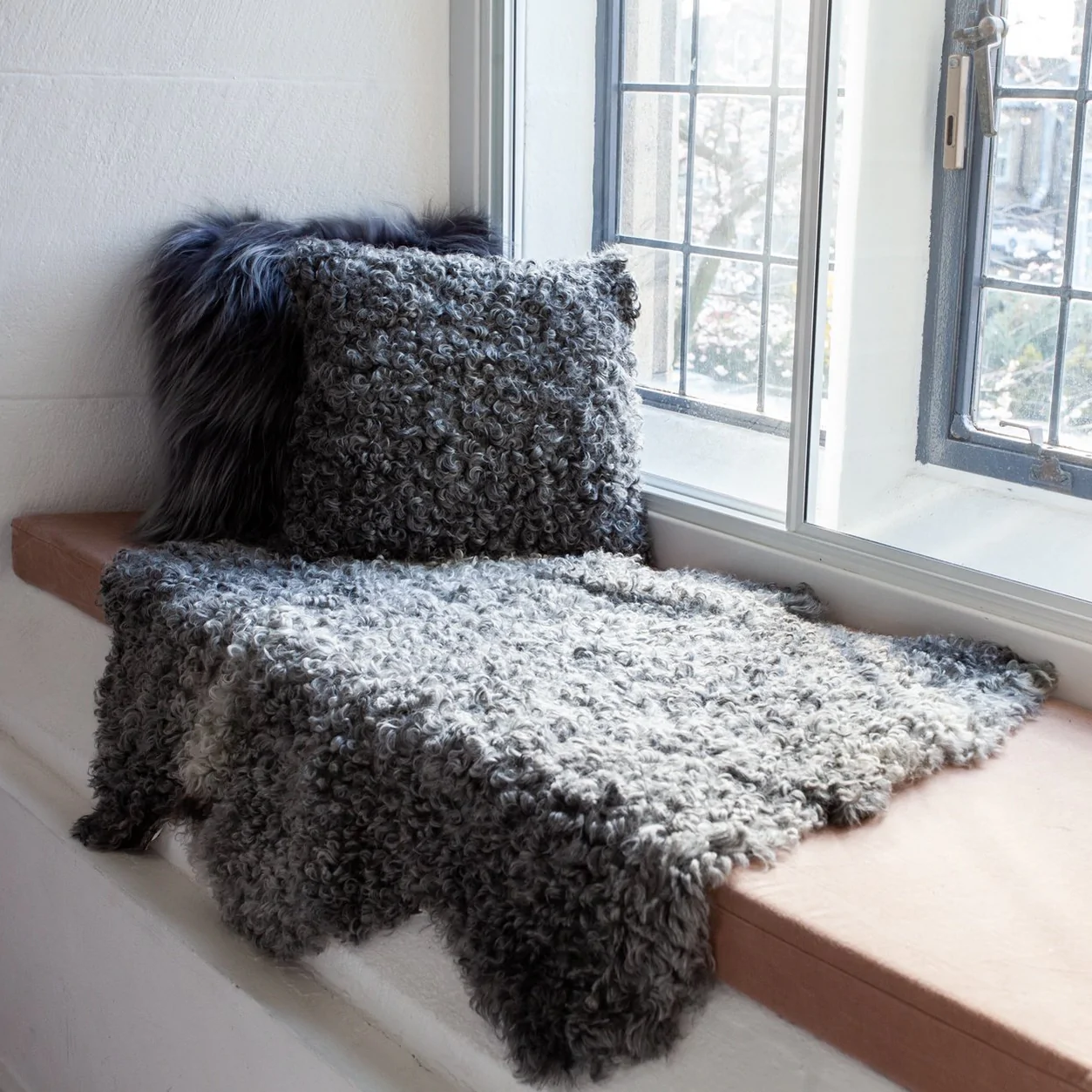 Gotland Sheepskin Cushion and Rug in Natural Grey.
