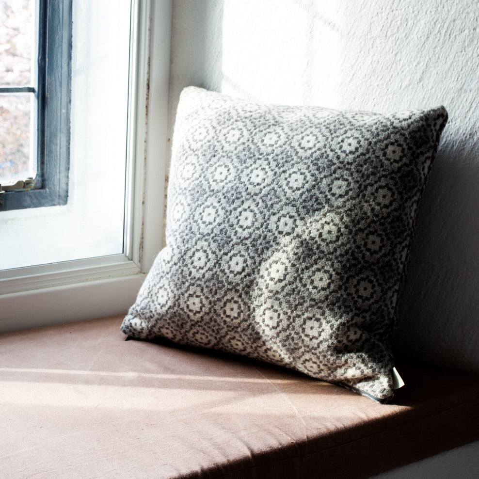 Melin Tregwynt wool woven Cushion in Origins Grey. Featured on a window seat.