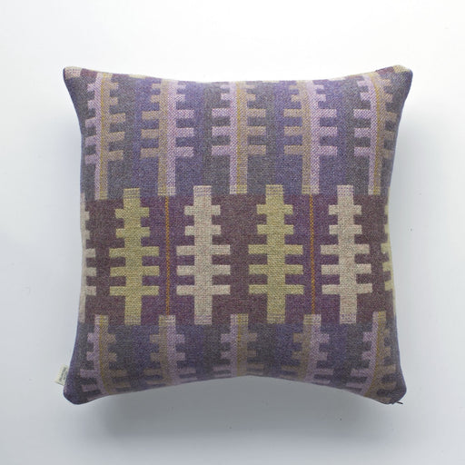 Forest Melin Tregwynt Woven Wool Cushion. A purple, green and cream cushion with tree like shapes woven with complimentary colours. A square shape with the melin Tregwynt label sewn into the side.