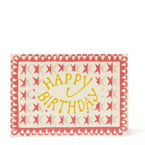 Happy Birthday Card. A horizontal card, features a red, cream and white stars illustrated background. In the centre of the card in yellow writing reads 'Happy Birthday'. Comes with an envelope.