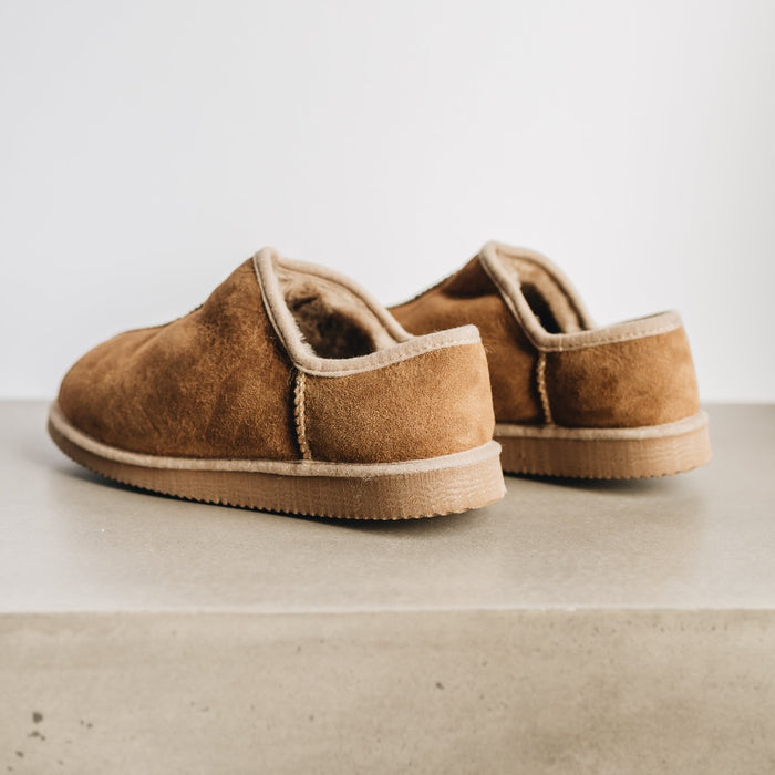 Back and side view of CADI Taupe Sheepskin Unisex Slipper, designed by Westmorland Sheepskins. Features a small branded cork tag sewn into outer trim.