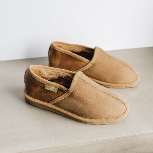 Side view of Beige Donald Men's Sheepskin Slippers. Shows the Beige front and warm brown rear heel, with complimentary beige seams and Westmorland Sheepskins branded sewn in tag.
