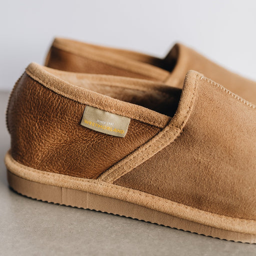 Donald Men's Slippers in Beige. Close up of warm brown heel and light brown seams, sole and front. Features the Westmorland Sheepskins branded sewn in tag.