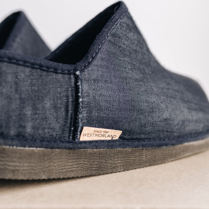 Close up of tag on CADI Navy Denim and Sheepskin Men's Slipper, designed by Westmorland Sheepskins. Features a small branded cork tag sewn into outer trim.