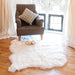 Quad Short Wool Icelandic Sheepskin Rug in white, draped on floor with armchair and slippers.