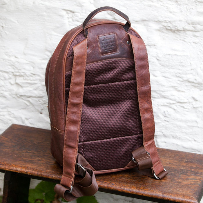 The back of the leather backpack showing leather straps and  back material
