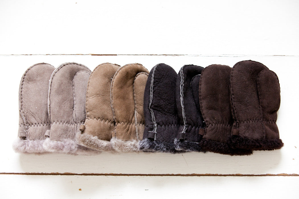 A row of natural coloured Baby and Toddler Sheepskin Mittens with Thumbs. Features a small cuff of Sheepskin at the wrist.