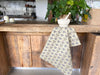 Polka Face Tea Towel draped over wooden counter top.