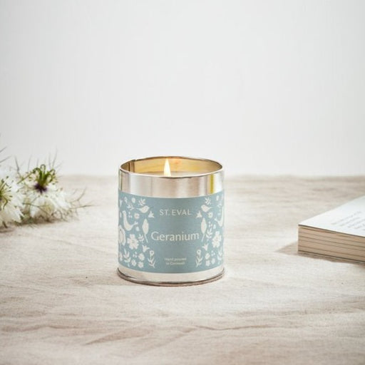 st eval candle company summer collection tin candle in geranium scent shown lit on a table