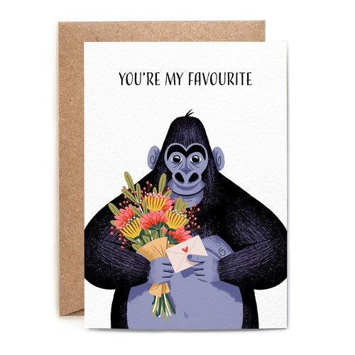 You're My Favourite, Gorilla Greetings Card. A white verticle rectangular greetings card. Features an illustrated gorilla smiling, holding a bunch of pink and yellow flowers and an envelope with a heart on it. At the top of the card reads 'You're My Favourite' in black handwriting. Comes with an envelope.