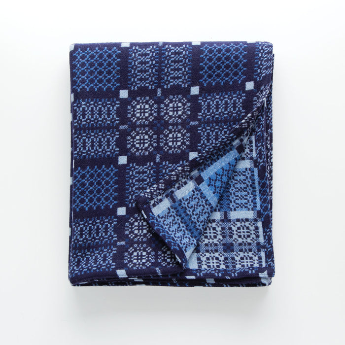 Indigo Blue Melin Tregwynt Knot Garden Woven Wool Throw. A deep Indigo blue colour, with detail pattern in white, grey and light blue.