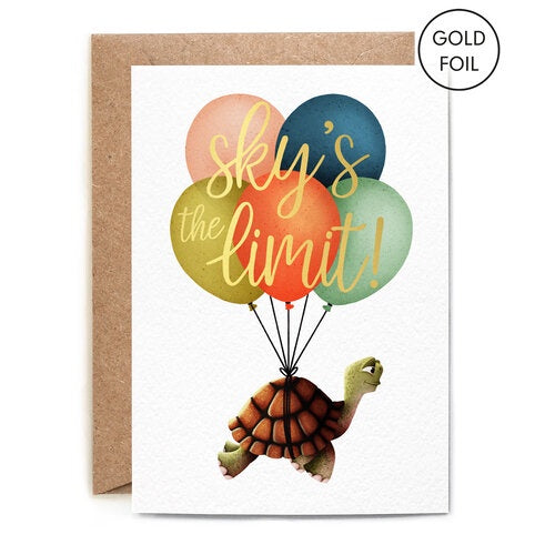 Sky's the Limit Greetings Card. A verticle card, features a Tortoise with balloons strapped around its shell, floating upward. On the balloon in gold foil writing reads 'Sky's the Limit'. Comes with an envelope.