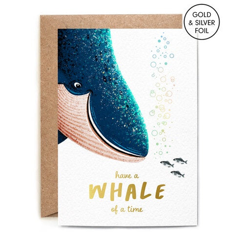 Whale of a Time Greetings Card. A verticle card, features a large whale smiling at some tiny blubbing fish. At the bottom in gold foil writing reads 'have a Whale of a time'. Comes with an envelope.