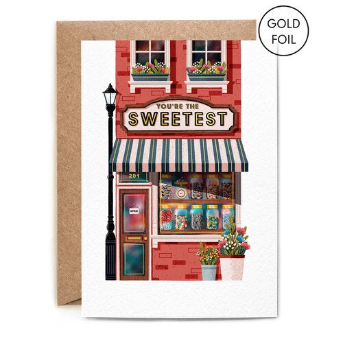 You're the Sweetest Greetings Card. A verticle card, features a sweet shop illustration, with the shop sign reading in gold foil' You're the Sweetest'. Comes with an envelope.